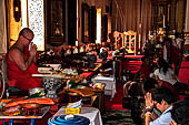 Chiang Mai - The Wat Phra Singh temple. Buddhist monk gives the blessing to woshippers. 